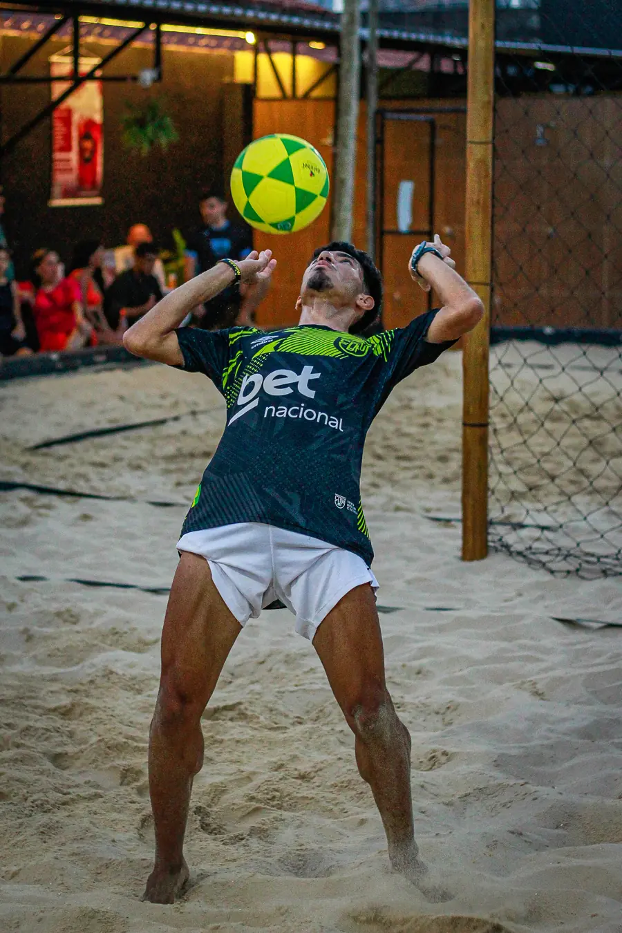Isaías dominando a bola no peito durante partida noturna